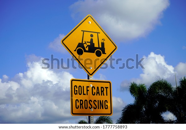 Golf Cart Crossing Street Sign\
with Cumulus Clouds in Background.                             \
