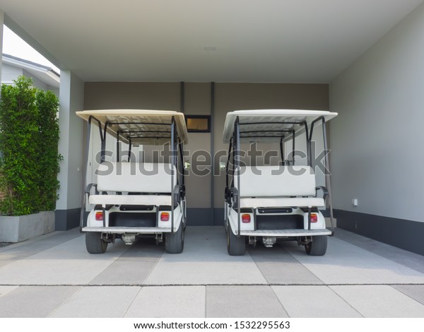 Golf cart, electric car in house area,\
parking lot waiting to be used as a shuttle\
service.