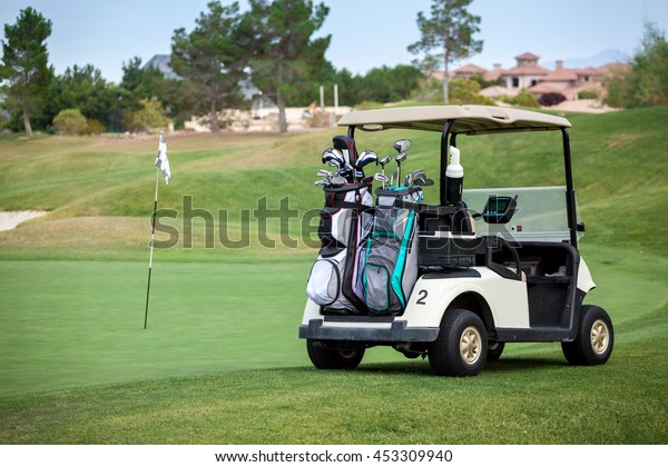 Golf cart on golf course in the afternoon with\
copy space.