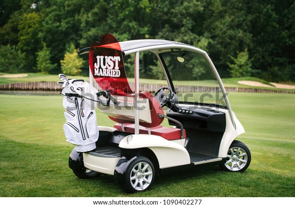 Golf\
cart on golf course, copy space. Just married sign on red heart on\
empty golf car outdoors. Wedding concept. Golf\
club