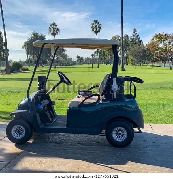 Golf cart parked by golf\
course