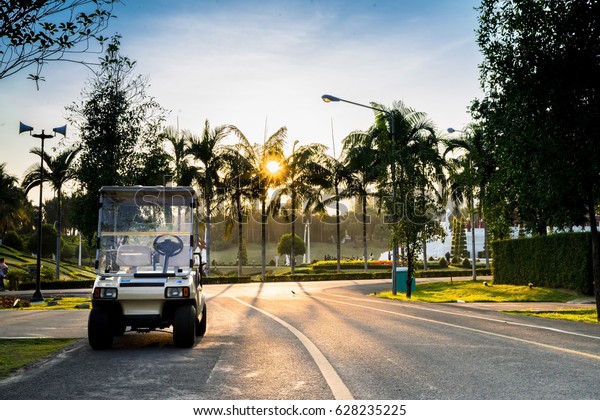 Golf carts or golf club cars in the garden a\
beautiful on sunset