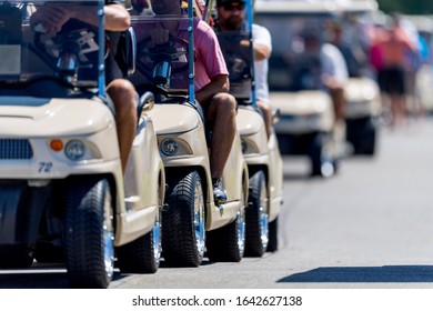 Golf Carts Lined Up On A Asphalt Pathway