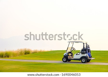 Golf carts on the green yard in the morning.