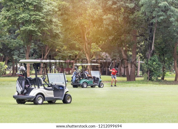 Golf carts\
parked on green fairway at golf\
course