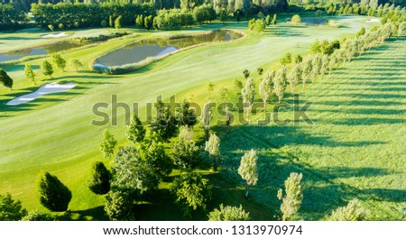 Similar – A tranquil aerial view of a lush golf course fairway, bathed in the warm glow of sunset. Ideal for themes of relaxation, nature, and sports, this image captures the peaceful beauty of the golfing experience.