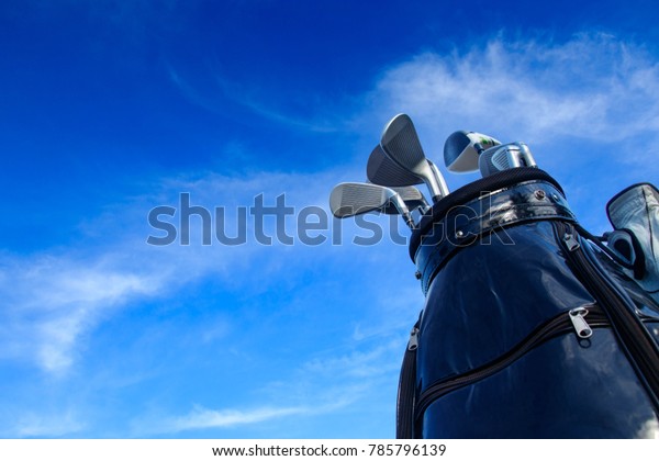 Golf club in bag\
with blue sky background.