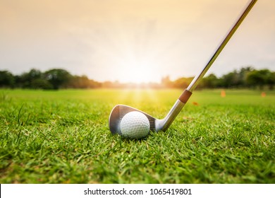 Golf Club And Golf Ball In Grass In Sunrise.	