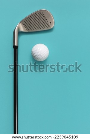 Golf club and golf ball isolated on light turquoise blue background. Space for text.