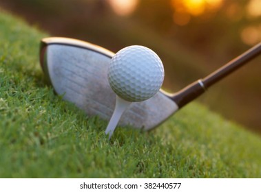 Golf Club And Ball On Grass At Evening Twilight Sunset