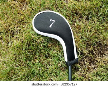 A Golf Club Covered With Labeled Head Cover Laid On The Grass