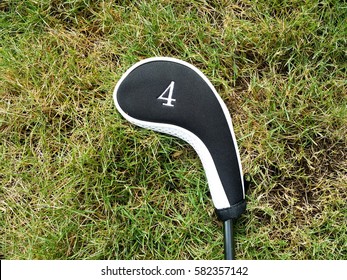 A Golf Club Covered With Labeled Head Cover Laid On The Grass