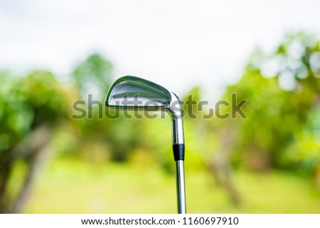 A golf club of gofer used in golf competition with blur green tree background.