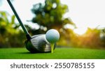 Golf clubs and golf balls on a green lawn in a beautiful golf course with morning sunshine. Close up of golf equipment on green grass.                                   