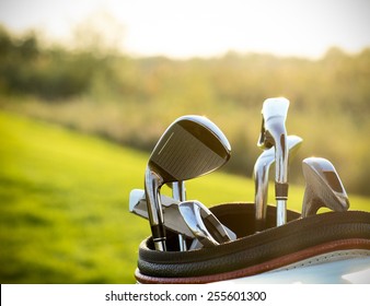 Golf Clubs Drivers Over Green Field Background. Summer Sunset