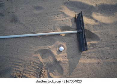 Golf concept. Golf ball and rake sand on bunker in beautiful golf course at sunset background.                                 - Powered by Shutterstock