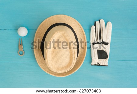Golf concept : panama hat, glove, golf balls, divot repair tool on wooden table. Flat lay with copy space.