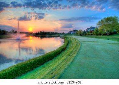 Golf Course Fairway And Hole At Sunrise In Golfing Community