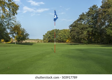 Golf Course in Forest - Golf Green With Flag in the hole.