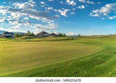 Golf Course And Homes With Blue Sky And Puffy Clouds Overhead On A Sunny Day