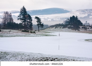 A golf course in Scotland on a snowy winter morning shortly after sunrise.