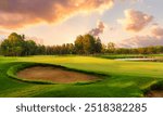 Golf course at sunset with beautiful sky and sand trap. Picturesque panoramic view