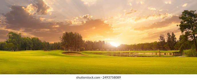 Golf course at sunset with beautiful sky and sand trap. Scenic panoramic view of golf fairway with bunker. Golf field with pines