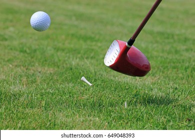 Golf Driver Club Hitting Ball Off A Tee On A Golf Course Fairway.