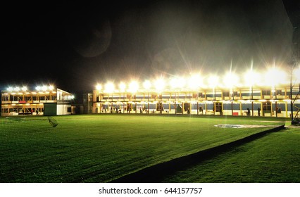 Golf Driving Range At Night Taken From Behind The Safety Netting. Wide Angle Bright Lights With Lens Flare.