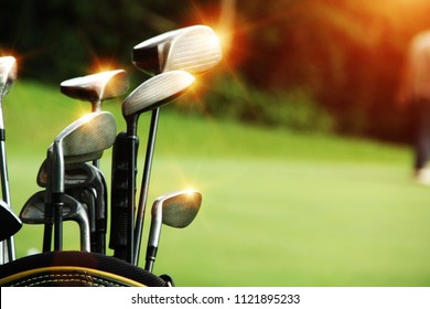 Golf Equipment In Beautiful Golf Course At Sunset Background.