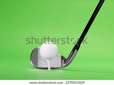 Golf Fairway Iron with a Golf Ball on White Tea, isolated on a Green Background