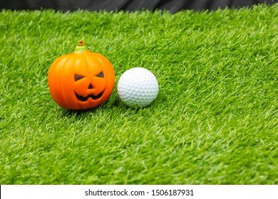 Golf Halloween With Golf Ball And Pumpkins Are On Green Grass