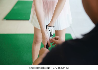 Golf instructor adjusting beginner golfer’s grip during lesson at driving range. Close up coaching moment focused on correct hand position, technique improvement, learning golf basics, and professional sports training.