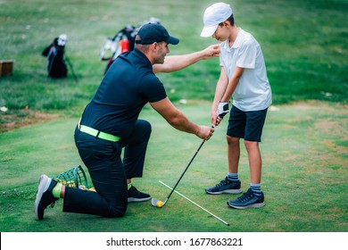 Golf Lessons. Golf instructor giving game lesson to a young boy. - Powered by Shutterstock