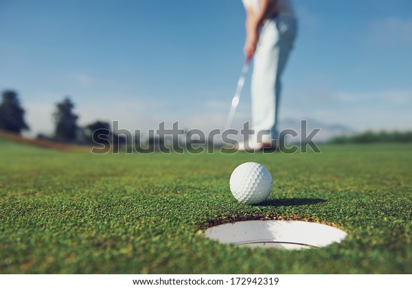 Golf\
man putting on green for birdie while on\
vacation