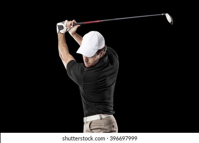 Golf Player In A Black Shirt Taking A Swing, On A Black Background.