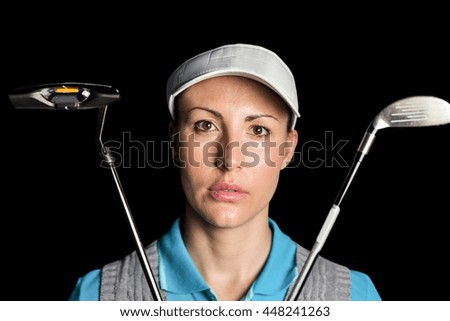 Golf player posing with golf club on black background