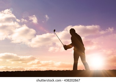 Golf player taking a shot against clouds