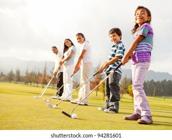 Golf players of all ages practicing to hit the ball at the course