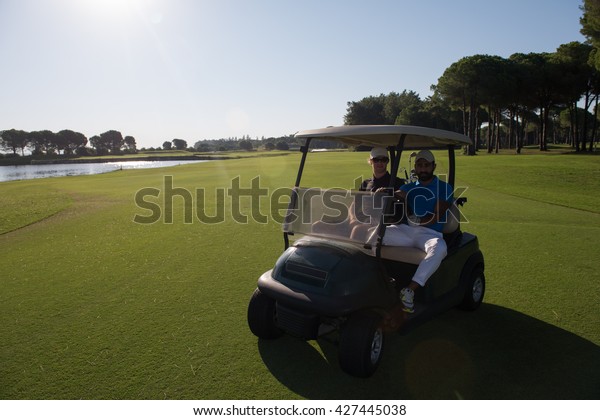 golf
players driving cart at course on beautiful morning sunrise.
friends together have fun and relax on
vacation.