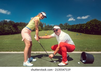 Golf Pro Teaching A Woman Student Of The Driving Range