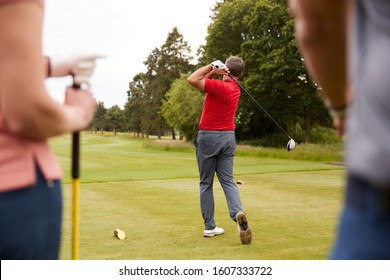 Golf Professional Demonstrating Tee Shot To Group Of Golfers During Lesson