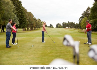 Golf Professional Demonstrating Tee Shot To Group Of Golfers During Lesson