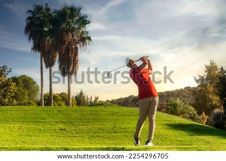 golf shot man. professional golf swing. Golf player teeing off. Front view of golfer finishing swing with a smile. Full length of golfer playing on the course. Golfer hitting golf shot with club