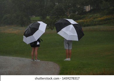 Golf Spectators Use Umbrellas As They Watch A Golf Tournament