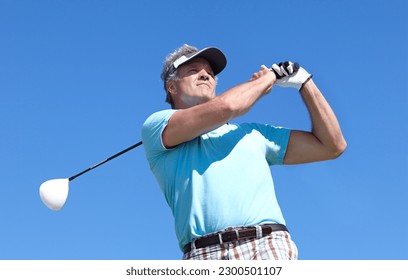 Golf, swing and elderly man with driver outdoor for training, hobby and sports on blue sky background. Club, swinging and active senior male golfer on field for retirement fitness, match or practice - Powered by Shutterstock