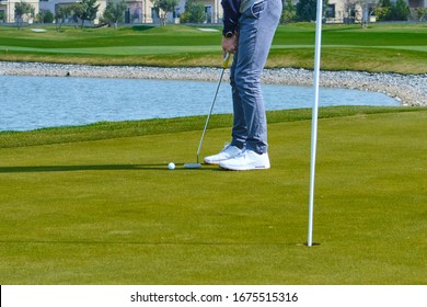 a Golfer hits the ball slowly to the hole. - Powered by Shutterstock