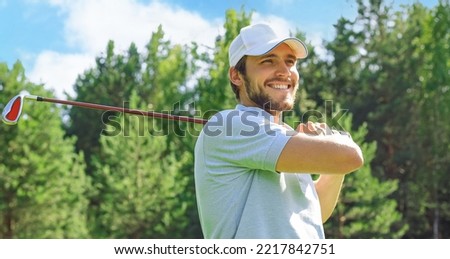 Golfer hits an fairway shot towards the club house