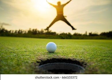 golfer jumping happiness after putt golf ball straight running to hole