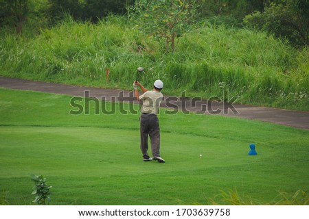 Golfer kicks the ball. Summer landscape - golf course. Fresh emerald grass, activity and sport. Empty golf course.